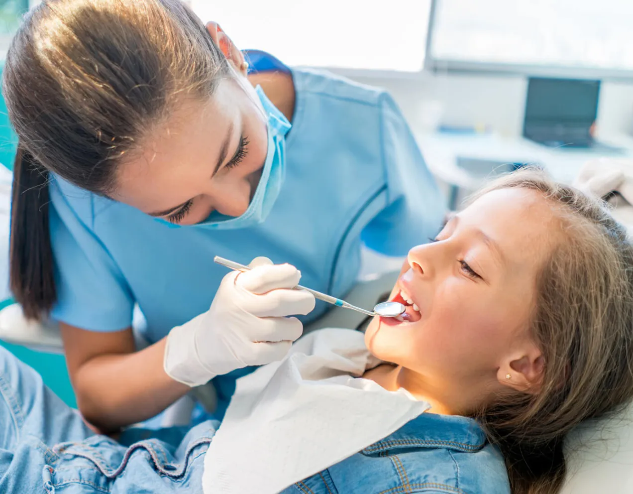 Day in the life of a dental assistant as they performs oral-cavity inspection on child with mouth-mirror