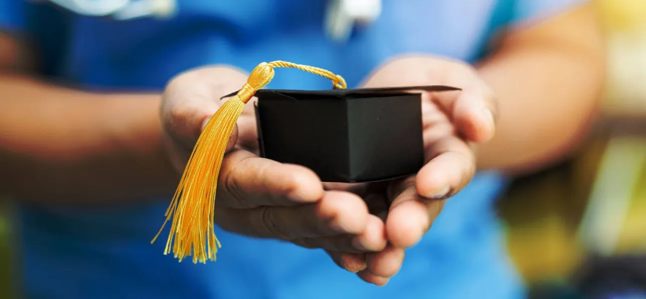 Holding a mini graduation cap