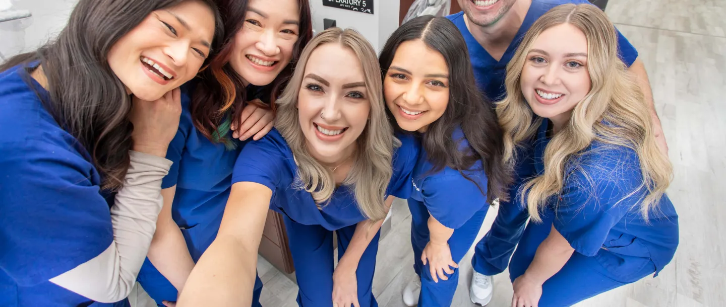 Concorde graduates in scrubs taking a fun selfie.