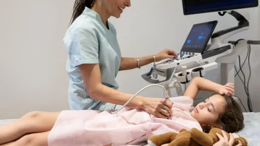 Echocardiographer exams child.