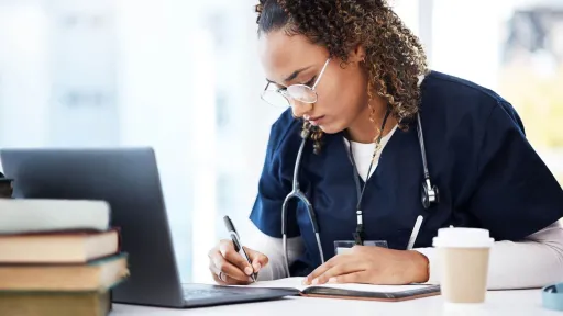 Nursing student in scrubs studying online, representing RN to BSN program and Bachelor of Science in Nursing coursework.