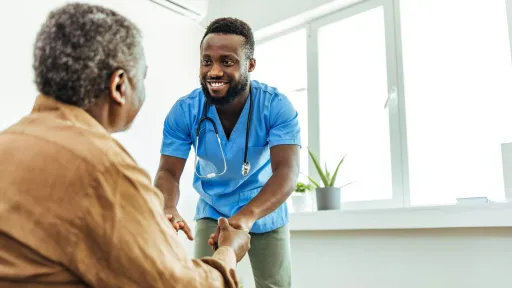 BSN-prepared nurse helping a patient stand, highlighting supportive, hands-on care in registered nursing roles.