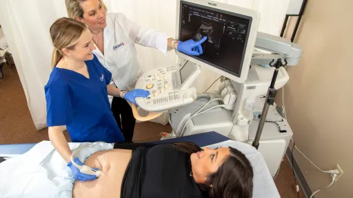 Concorde instructor teaching ultrasound student how to read sonogram image during hands-on training