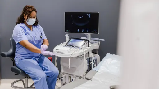 Sonographer preparing ultrasound machine at start of shift in exam room