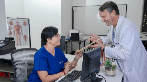 female medical office adminstrator hands file to physician in medical office