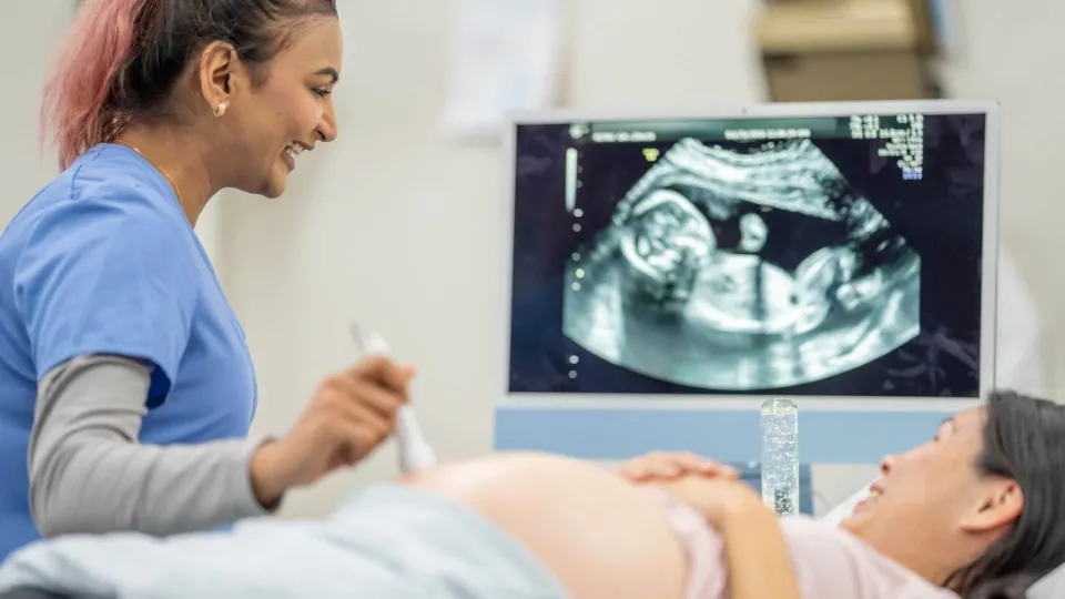 Ultrasound tech performing pregnancy ultrasound.