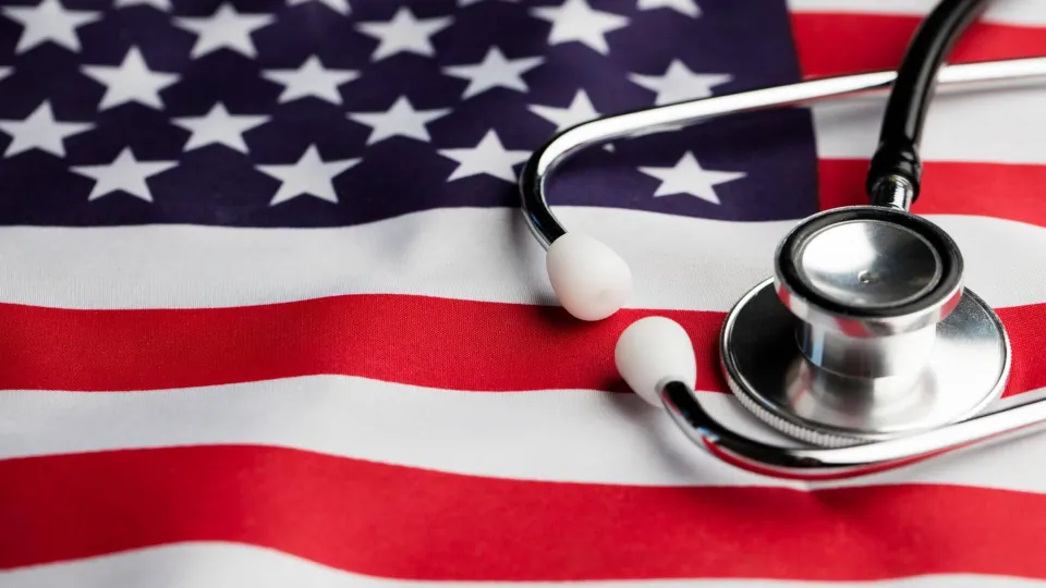 A medical stethoscope resting on a United States flag, representing the use of military tuition assistance for healthcare career training and veteran medical education programs.