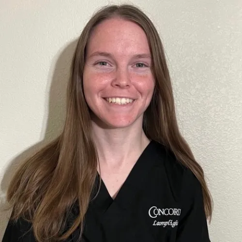 Female-Concorde-student-wears-black-Lamplighter-scrubs-and-smiles-for-camera