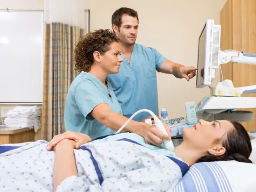 Diagnostic medical sonography being performed on patient's thyroid.