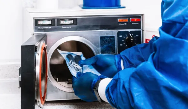 Sterile processing technician loading instruments into autoclave, demonstrating key skills learned in technician training.