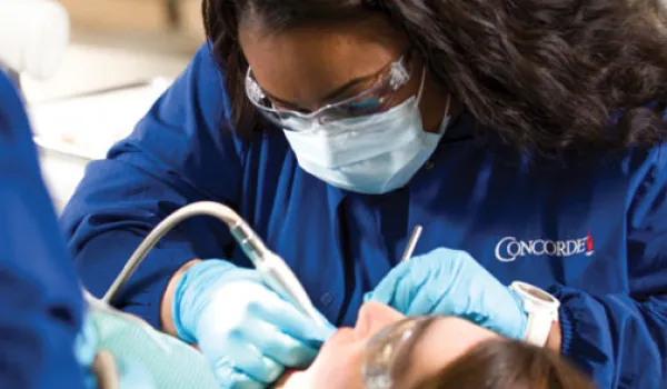 Concorde Career College Dental Assistant student suctioning mouth up close