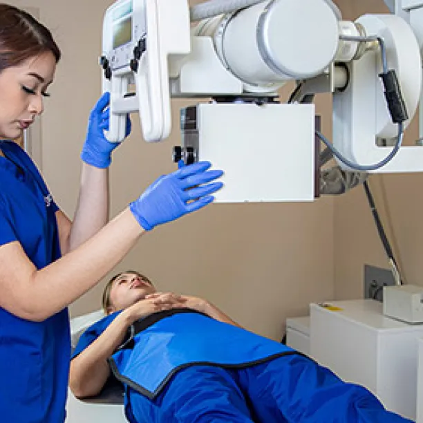 A radiology tech gives x-ray to patient's knee.