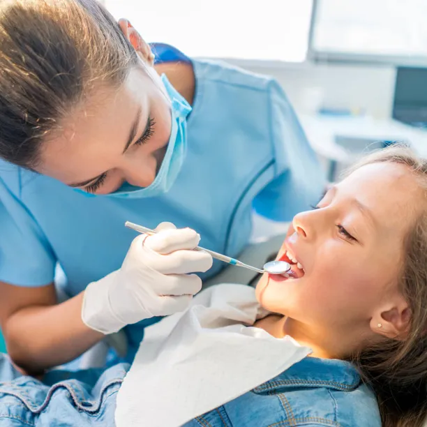 Day in the life of a dental assistant as they performs oral-cavity inspection on child with mouth-mirror