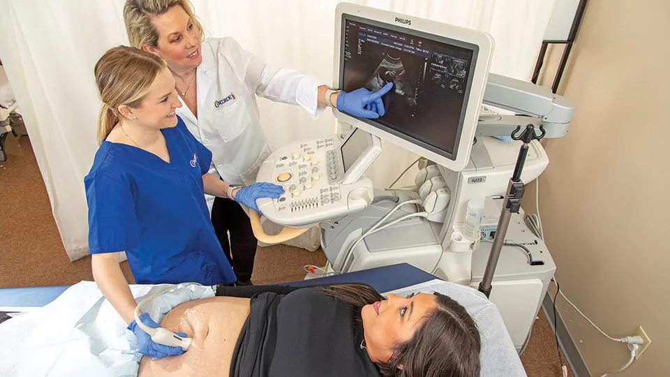 Diagnostic medical sonographer performs ultrasound on expecting mother Diagnostic medical sonographer performs ultrasound on expecting mother.