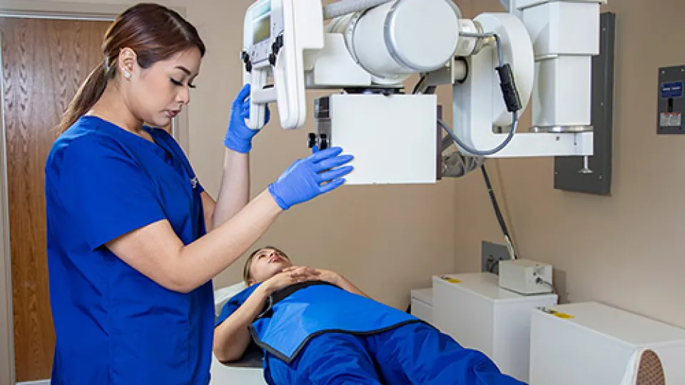 A radiology tech gives x-ray to patient's knee.