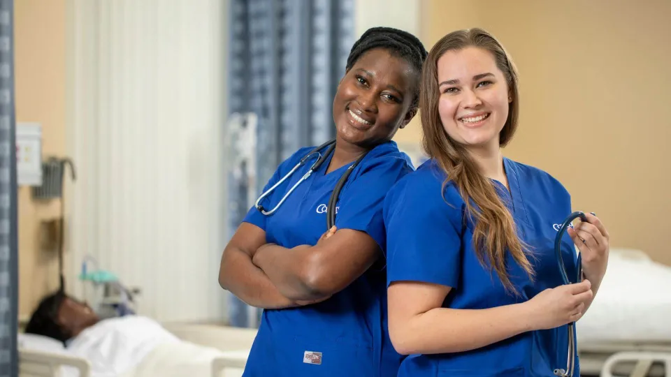 Two Concorde nursing students smiling wearing blue scrubs and stethoscopes Two Concorde nursing students smiling wearing blue scrubs and stethoscopes