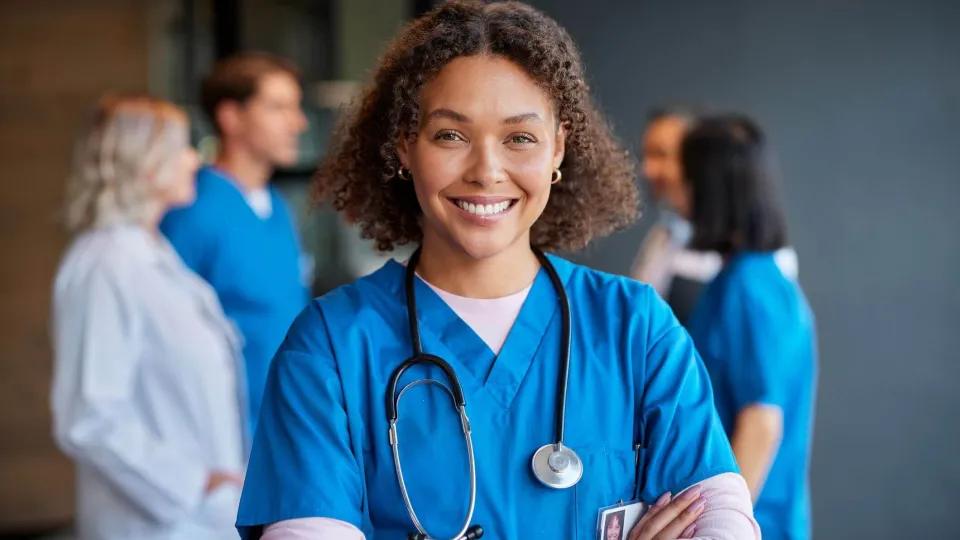 Registered nurse with BSN smiling confidently, representing leadership and patient care in clinical nursing environments. Registered nurse with BSN smiling confidently, representing leadership and patient care in clinical nursing environments.