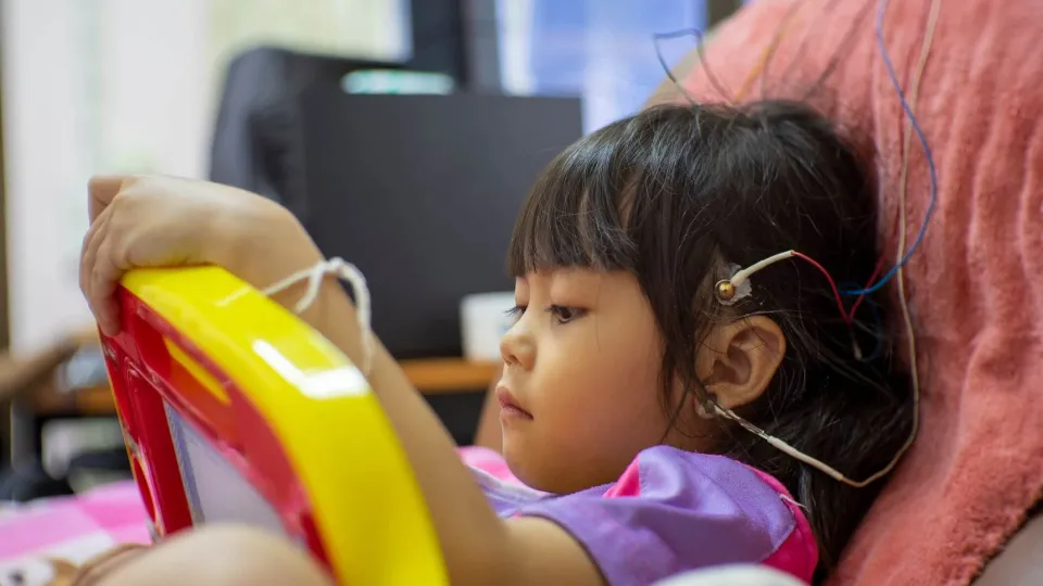 A Neurodiagnostic Technologist performs an electroencephalogram (EEG) on a young child, placing electrodes on the scalp as part of their clinical training for a key neurodiagnostic course. A Neurodiagnostic Technologist performs an electroencephalogram (EEG) on a young child, placing electrodes on the scalp as part of their clinical training for a key neurodiagnostic course.