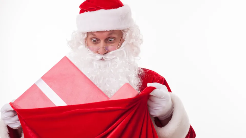 Cheerful Santa Claus is carrying a bag of presents health care college
